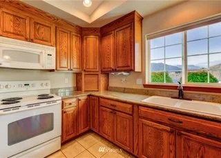 Kitchen with upper and lower cabinets with tile flooring at 104 Quail Lane Cashmere WA 98815