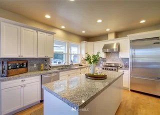 Kitchen with large island, upper/lower cabinets and stainless steel appliances at 2125 118th Ave E Edgewood WA 98372