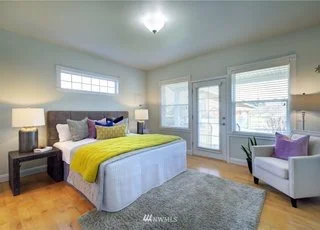 Bedroom with hardwood floors, three windows and glass framed door to deck at 2125 118th Ave E Edgewood WA 98372