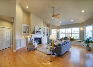 Open concept living room with fireplace, ceiling fat and hardwood floors at 2125 118th Ave E Edgewood WA 98372