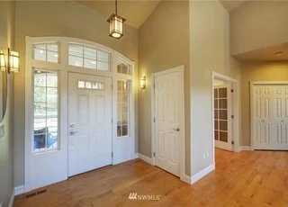 Front door and foyer area with hardwood floors and closet of 2125 118th Ave E Edgewood WA 98372