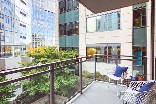 Balcony with lounge area and city view at 820 Blanchard St #810 Seattle WA 98121