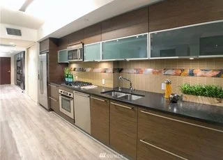 Kitchen with upper and lower cabinets and hardwood floors at 820 Blanchard St #810 Seattle WA 98121