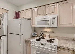 Kitchen appliances with partial view of stacked washer/dryer at 2530 15th Ave W #508 Seattle WA 98119