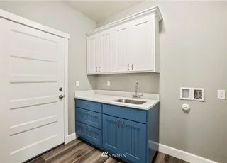 Utility room with upper and lower cabinets, sink and washer/dryer hook ups at 112 Skyhawk Dr Toledo WA 98591