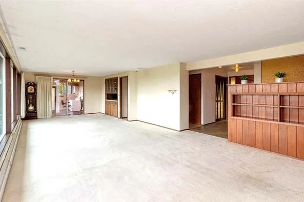 The great room with low pile carpeting, built in wall divider and wall of windows at 21700 Calhoun Road Monroe, WA 98272