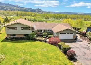 Front view of home wit driveway, double garage, landscaped pathways and expansive yard at 21700 Calhoun Road Monroe, WA 98272