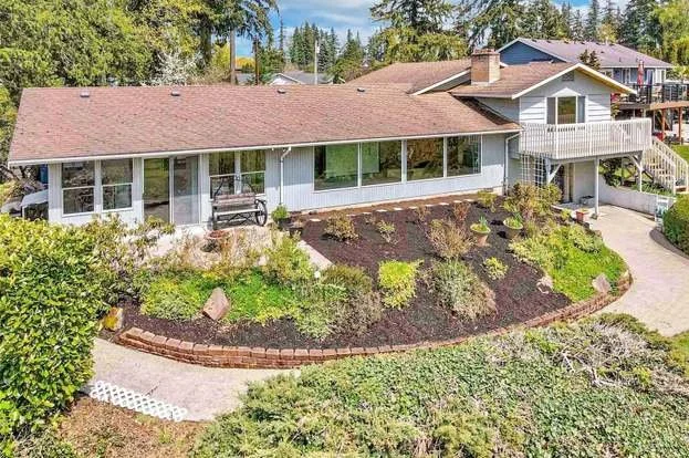 Backyard with landscaped garden and paved pathway at 21700 Calhoun Road Monroe, WA 98272