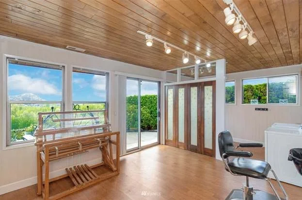 Sun room with track lighting, hardwood floors and sliding door access to backyard at 21700 Calhoun Road Monroe, WA 98272