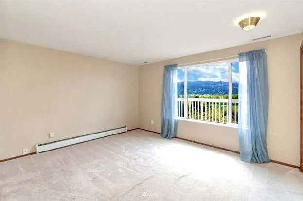 Bedroom with large window and low pile carpeting at 21700 Calhoun Road Monroe, WA 98272