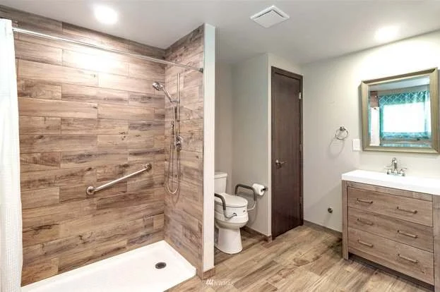 Bathroom with roll in shower, toilet with grab bars and window at 21700 Calhoun Road Monroe, WA 98272