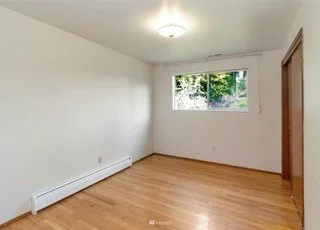 Bedroom with hardwood floors, small windows and closet at 21700 Calhoun Road Monroe, WA 98272