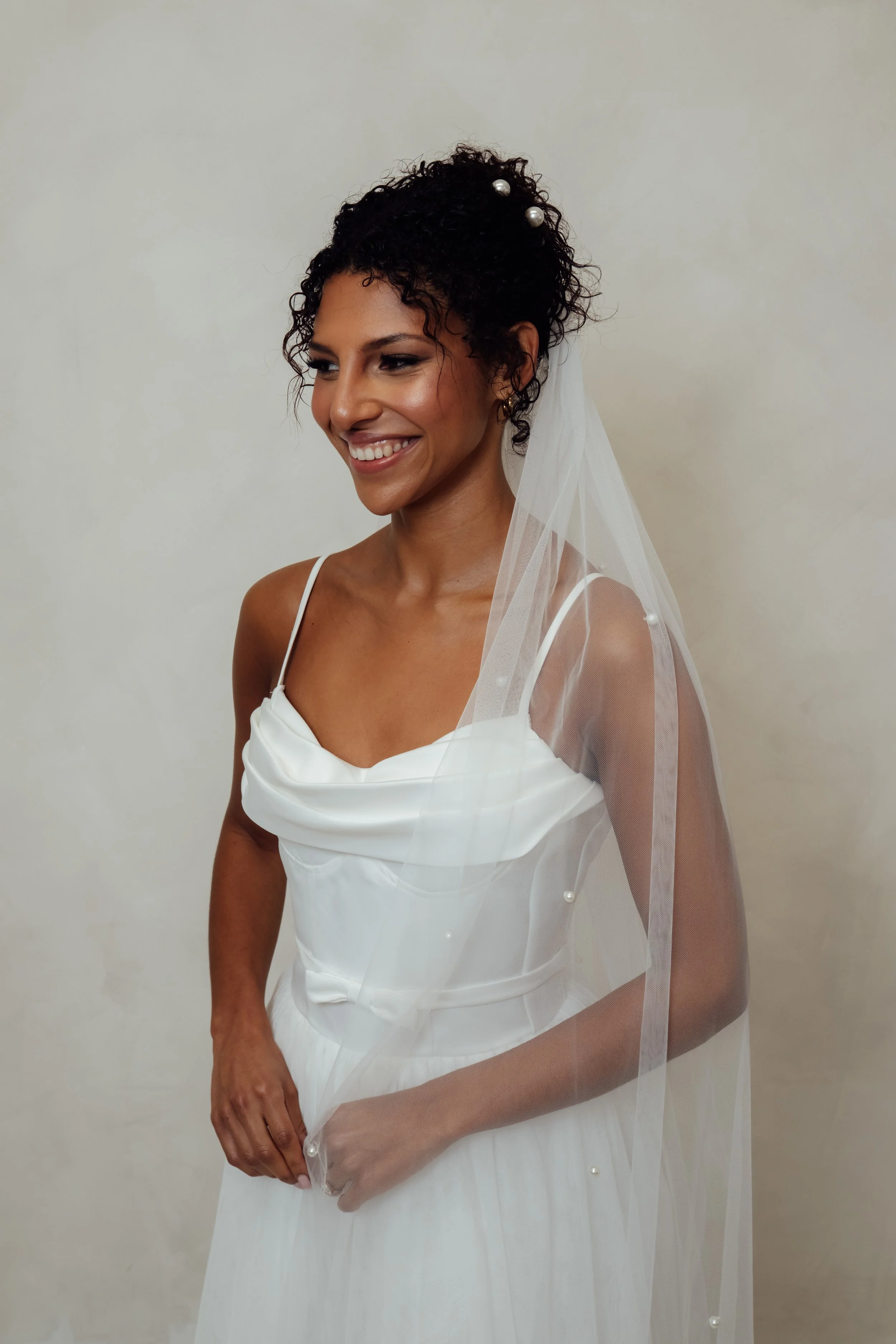 Model Chloe wearing The Pearl Veil, a soft Italian tulle bridal veil with delicate scattered pearl detailing