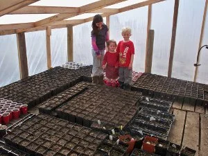 Kiddos Look over the Tomato Seedlings