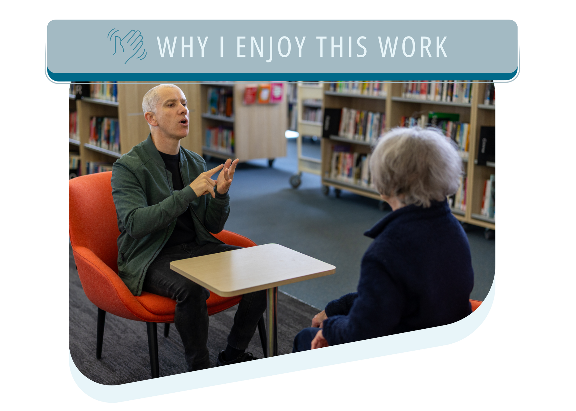 A man in a green jacket and black shirt sitting in a red chair opposite an older woman with gray hair sitting across from him in a library. They are engaged in conversation using Auslan sign language. The title says Why I Enjoy This Work