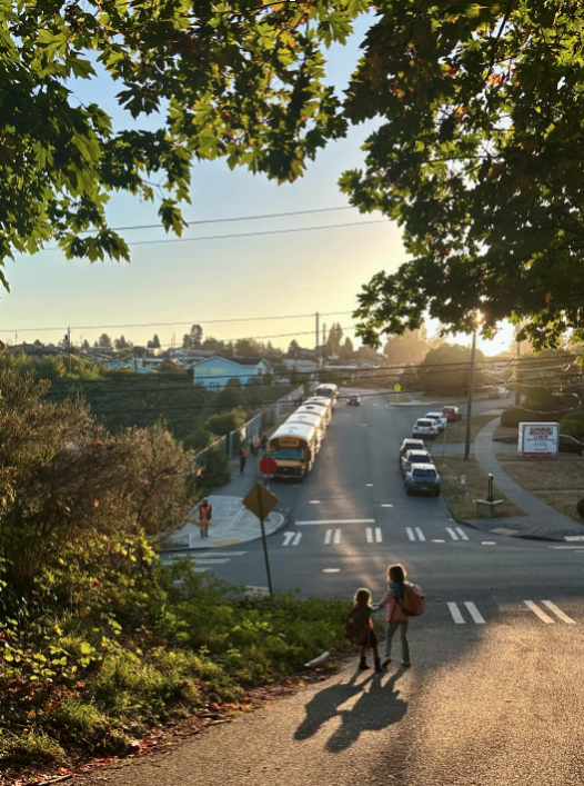 Kids walking down hill to North Beach Elementary with buses in background