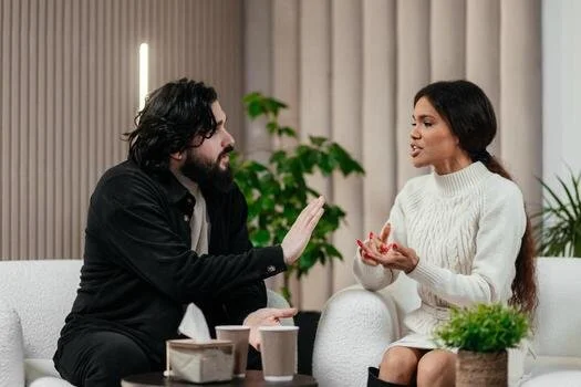 young-married-upset-couple-man-and-woman-sitting-on-sofa-in-counselor-office-during-family-therapy-session-with-male-psychologist-trying-to-find-solution-effective-marital-therapy-concept-photo.jpg