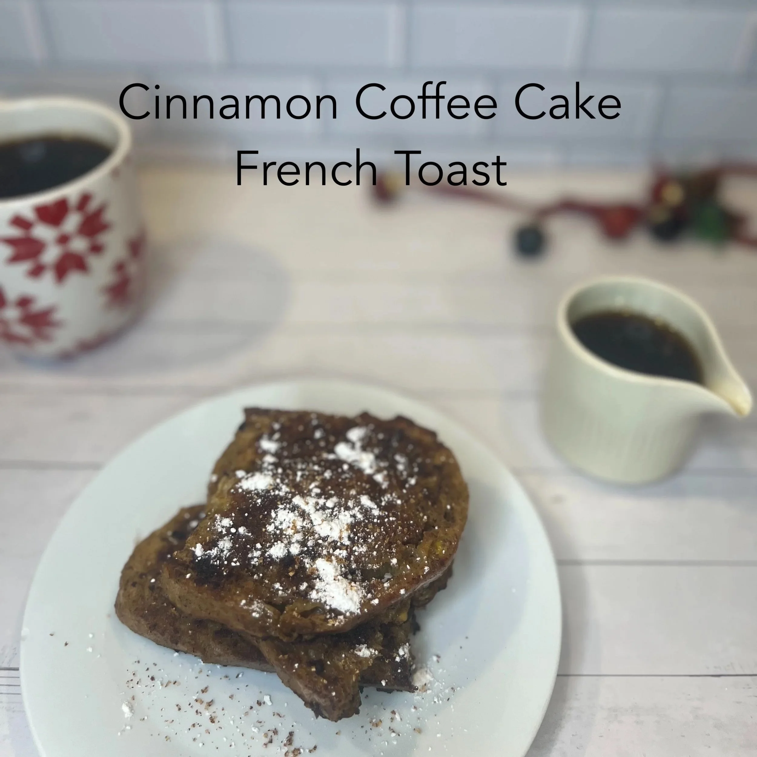 Plate with two slices of cinnamon coffee cake dusted with powdered sugar, accompanied by cups of black coffee and a small pitcher of coffee on a white table.