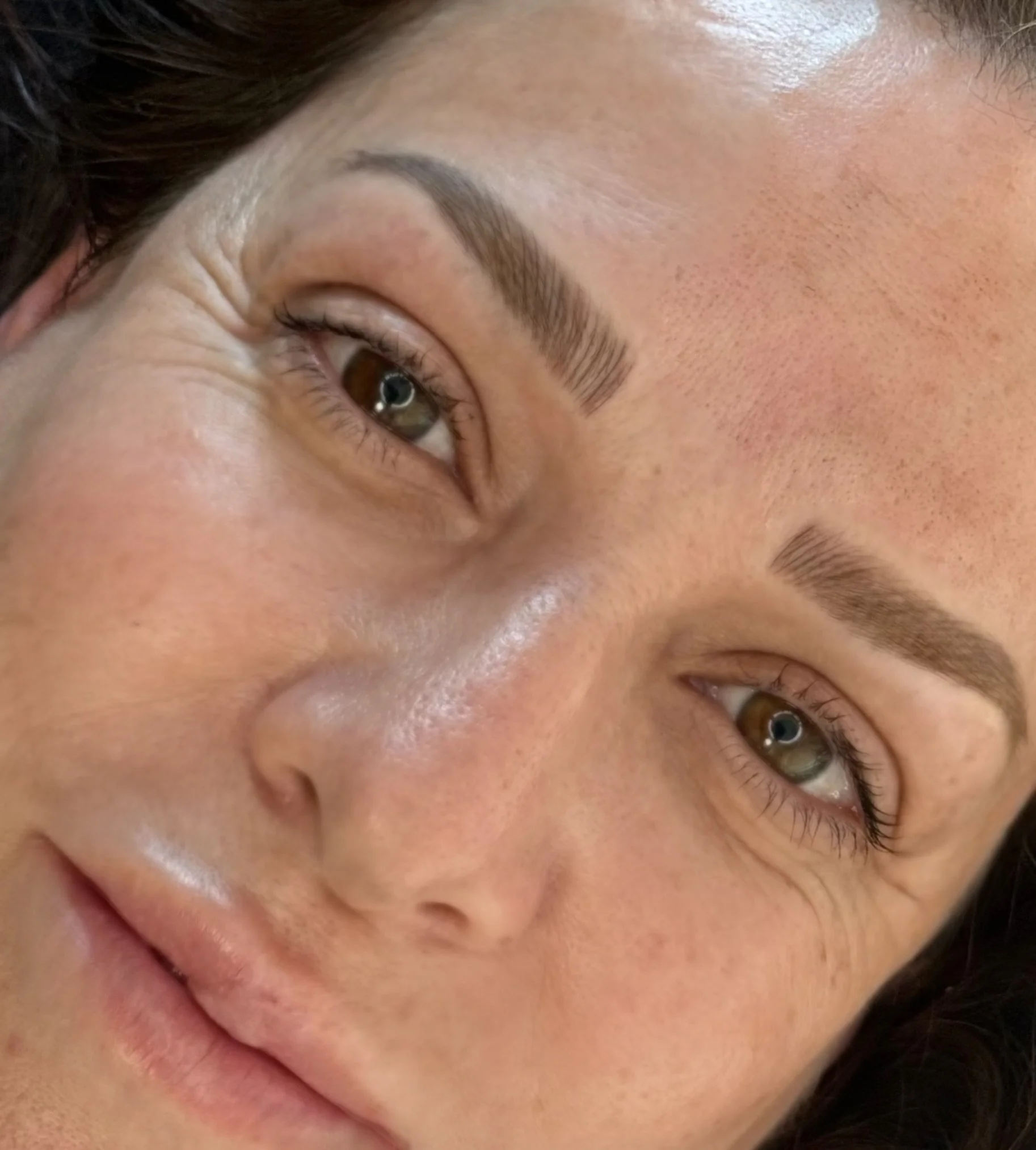 Close-up of a woman's face showing her forehead, eyebrows, eyes, nose, and lips.