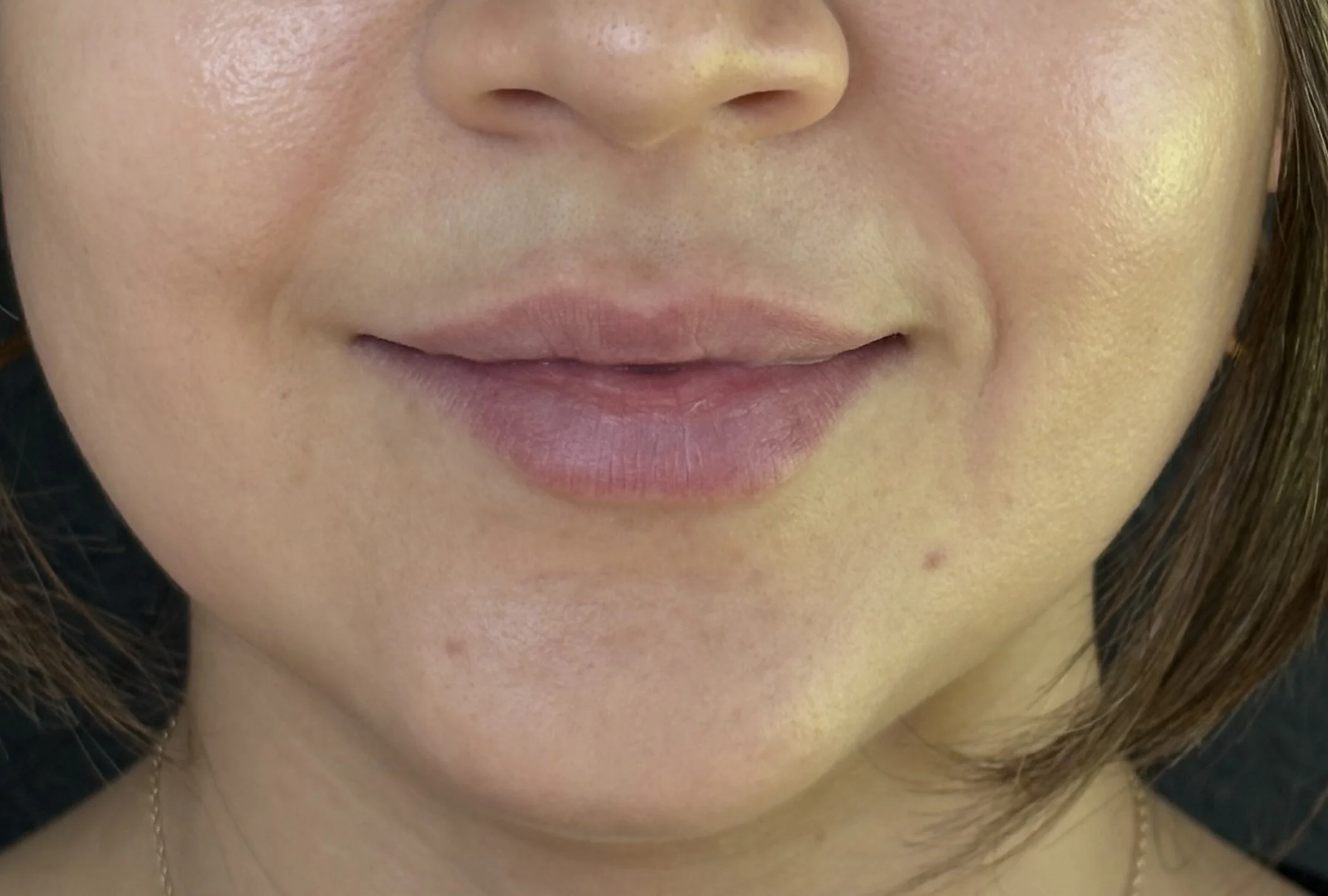Close-up of a woman's smiling face, showing her lips and part of her nose and cheek.