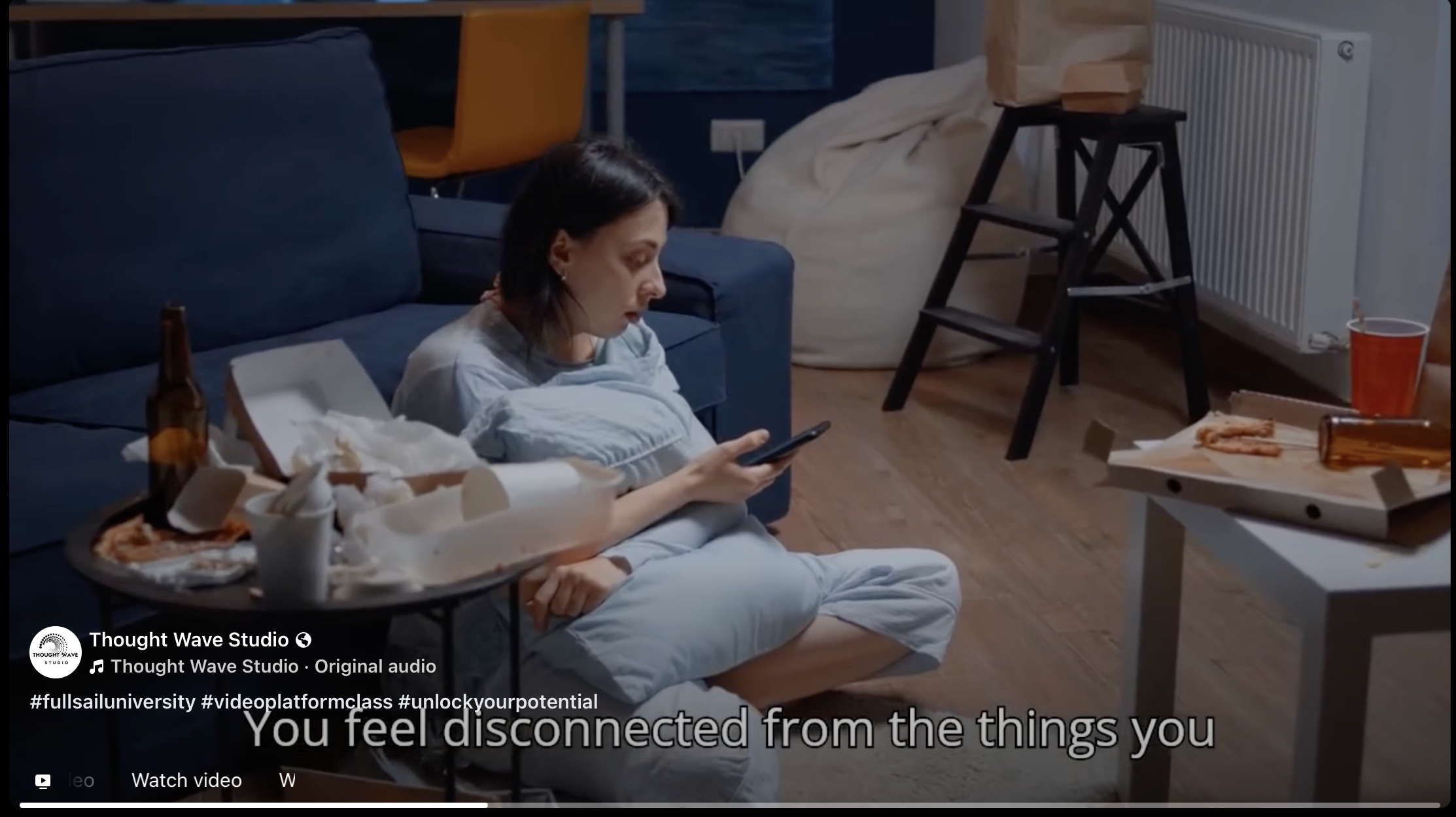 A woman sitting on the floor in a living room, looking at her phone, surrounded by empty pizza boxes, bottles, and remnants of food, with a mostly empty pizza tray in front of her.