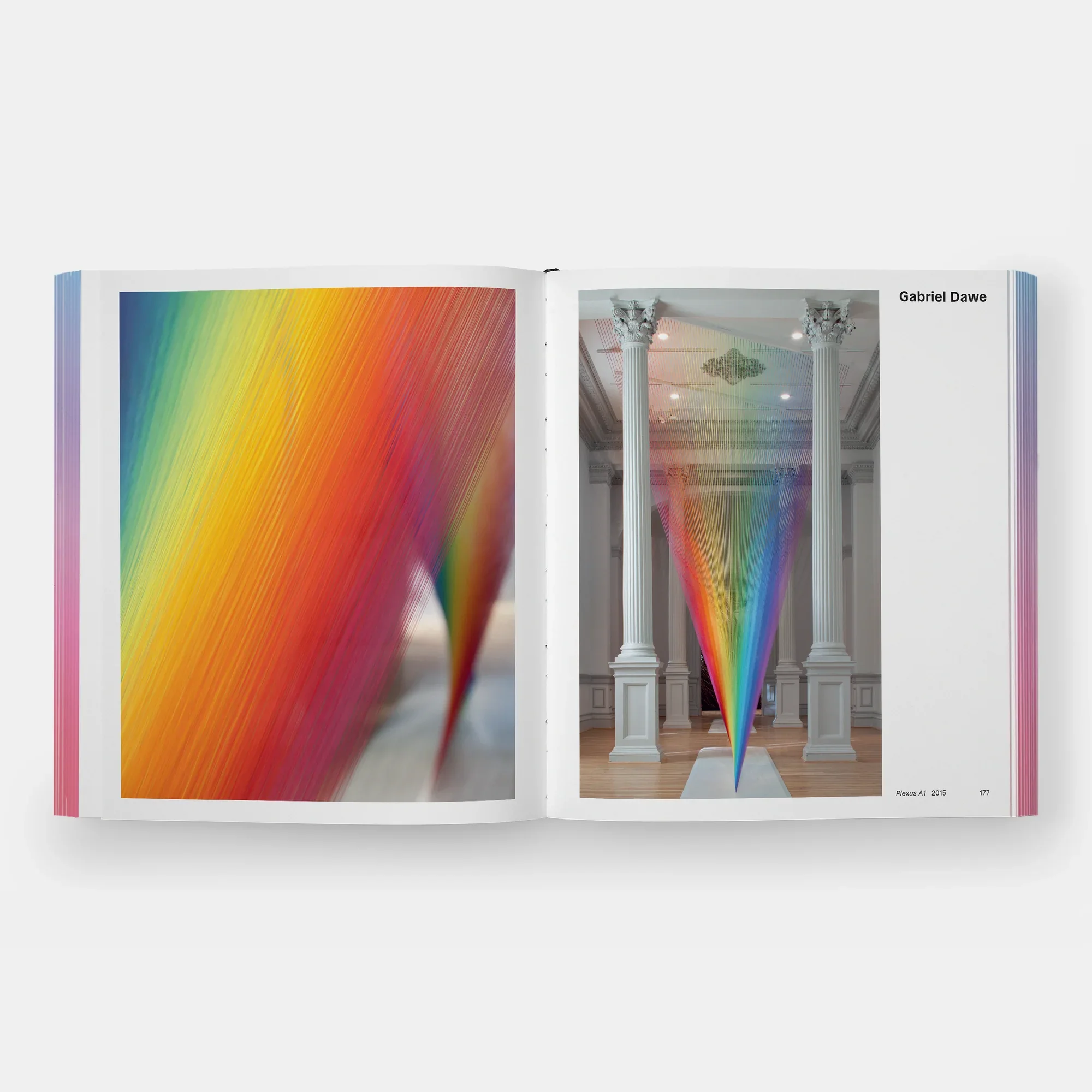 Rainbow Dreams Book by Olga Rei and Valentine Uhovski. Phaidon. Open book showing an art installation with a rainbow-colored light projection in a room with classical columns.