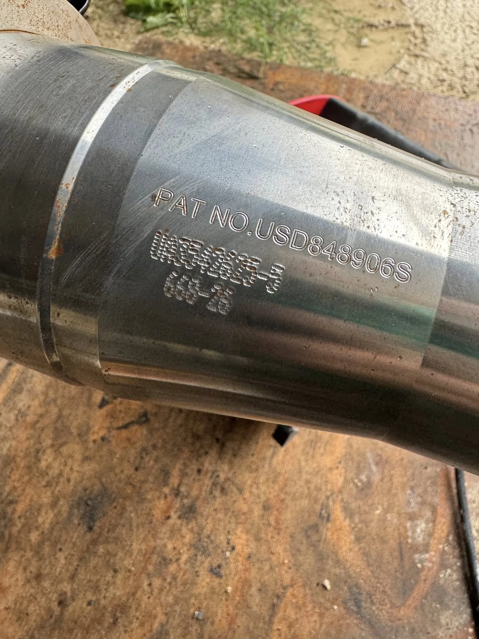 Close-up of a metal pipe with stamped patent and serial numbers on it.