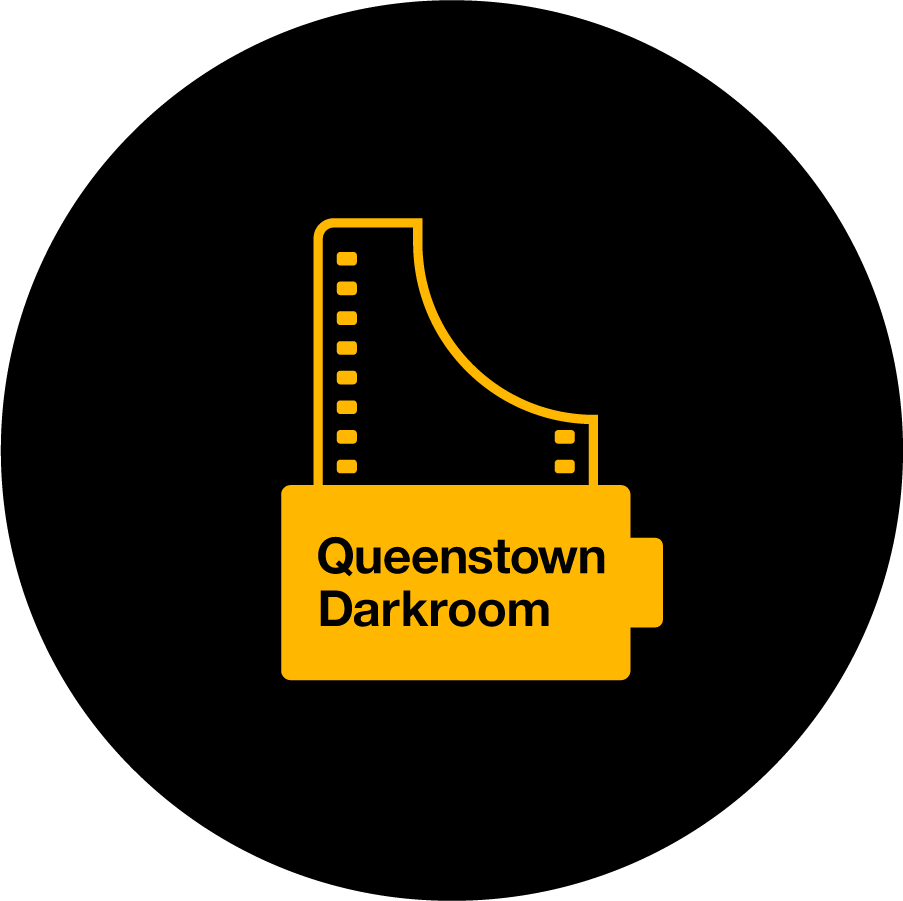 Gold version of the "Queenstown Darkroom" logo on a black background.