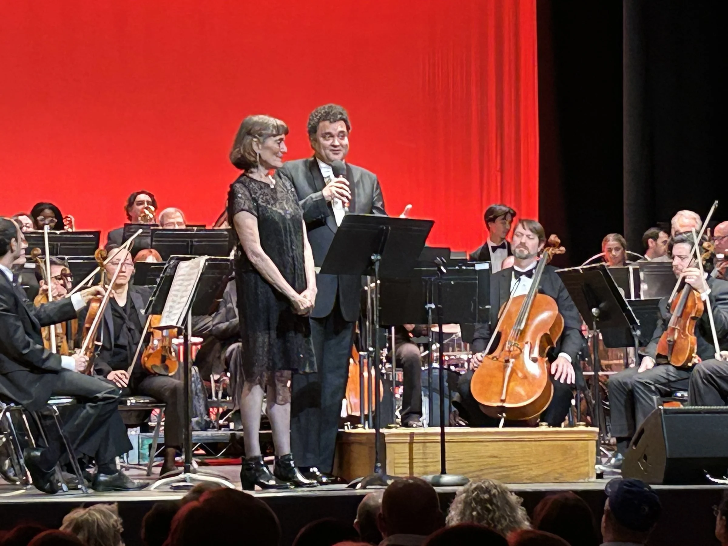 A guest speaker joins Music Director Eduardo Leandro on stage with the GBS orchestra