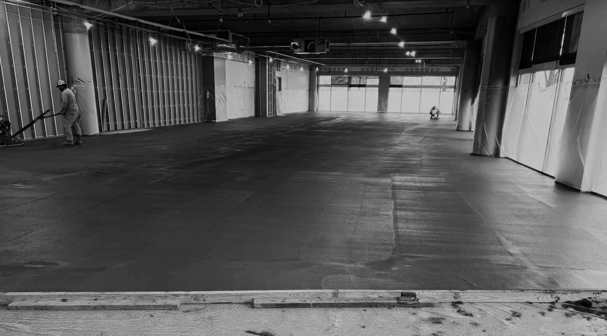 Interior of a building under construction with workers and partially finished floors. Construction Consulting Owner's Representative Nashville