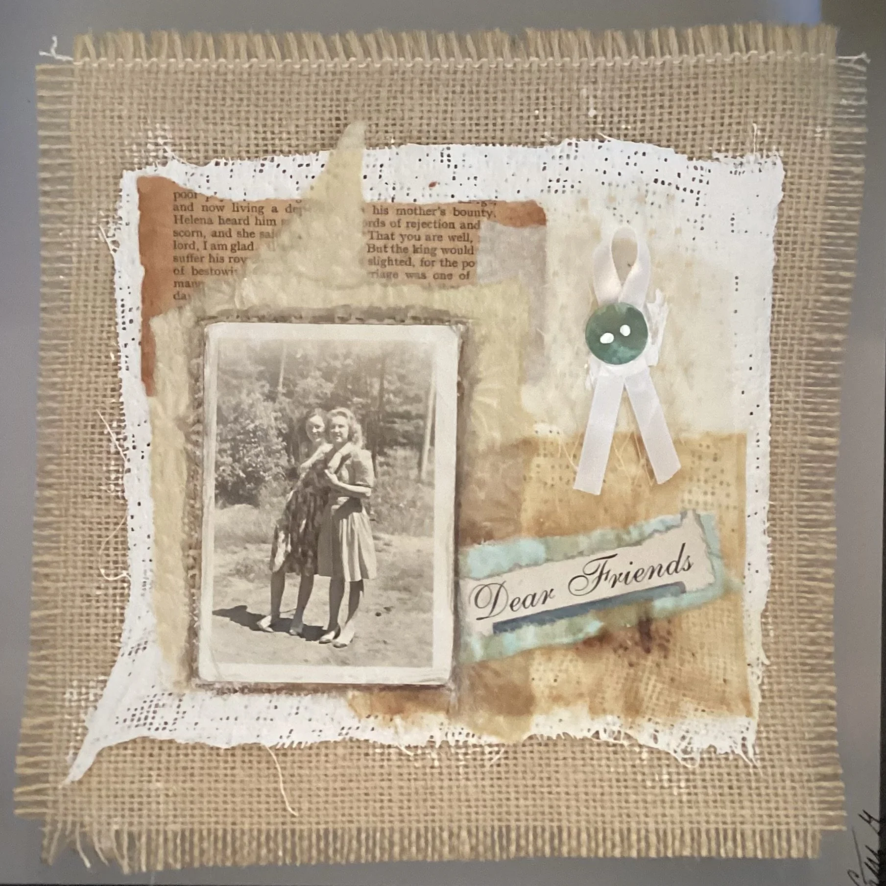 A scrapbook page with a black-and-white photo of two young women standing outdoors, surrounded by layered textured papers, torn edges, printed text, and a ribbon with a button. It includes a handwritten note that says "Dear Friends".
