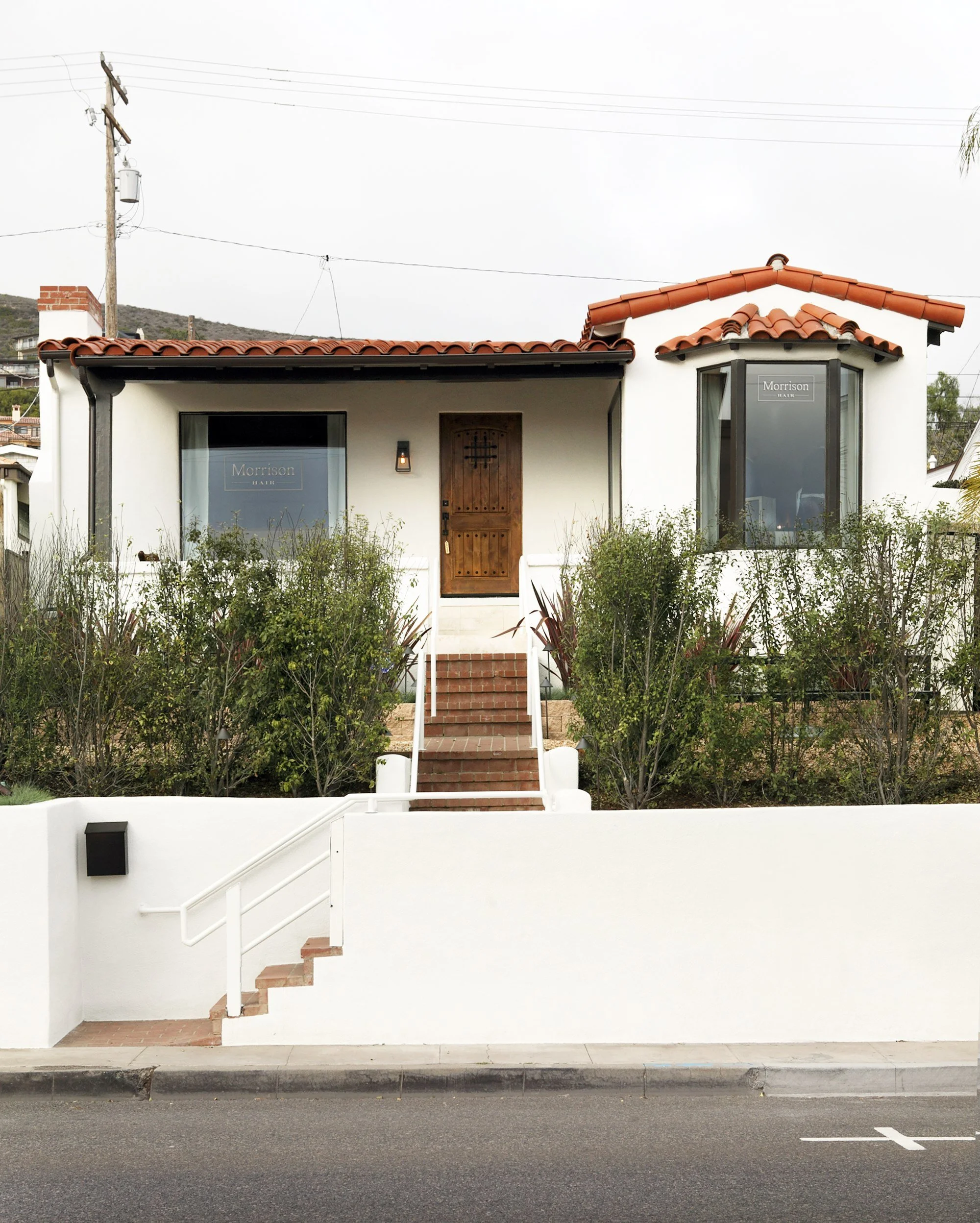 After: installed hedges and gravel to create a private and modern feel. Painted exterior. Reinforced and re-stuccoed walls.