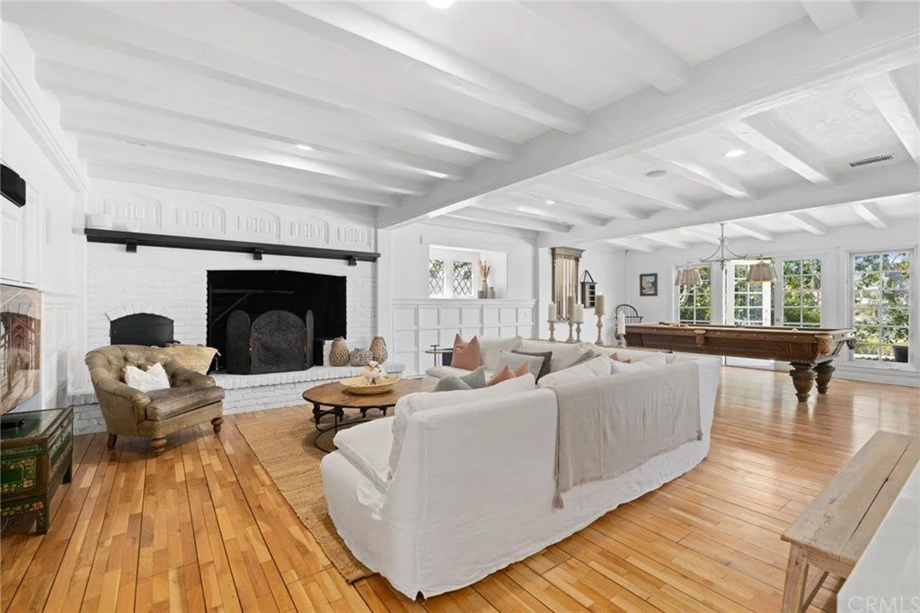 After: created a lighter and brighter room by painting beams, wall paneling and fireplace brick.