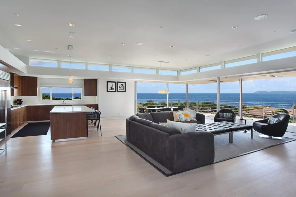 After: Corner disappears to fully capture the ocean view. Created open floorplan living room, dining room and kitchen space.