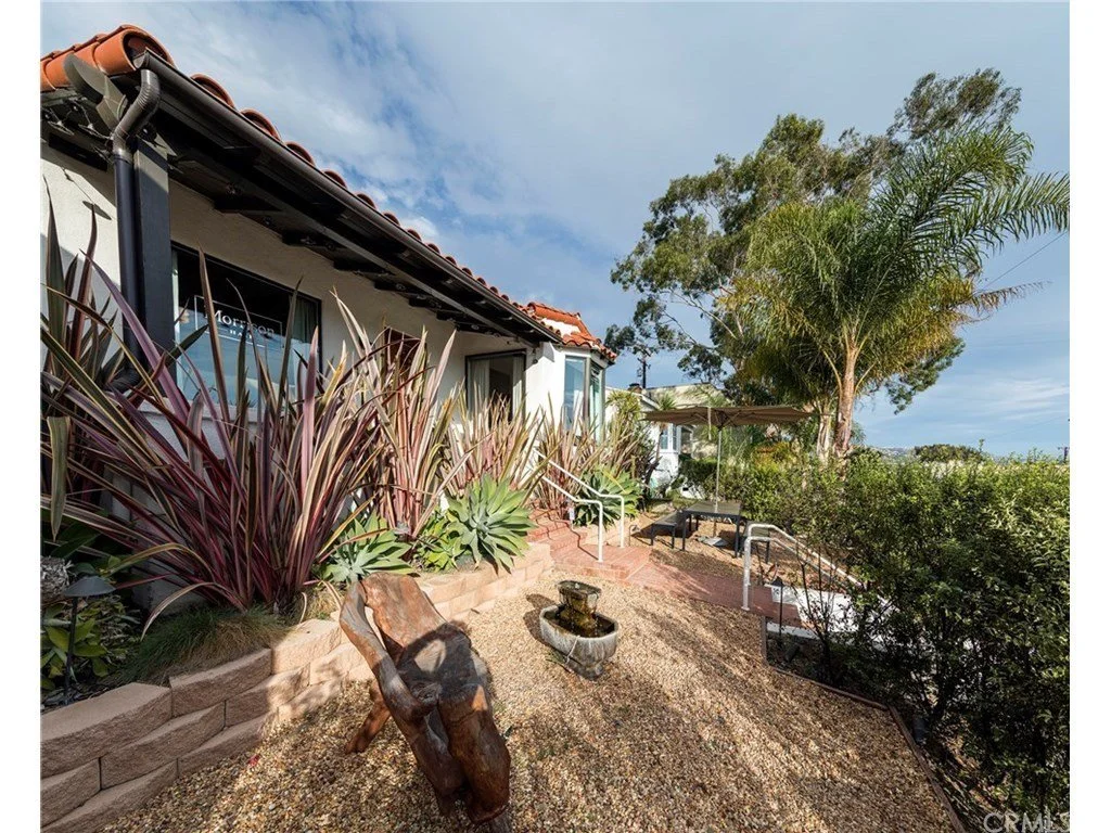 After: Installed plants that create a more Spanish vibe to exterior. Installed gutters and painted beams.