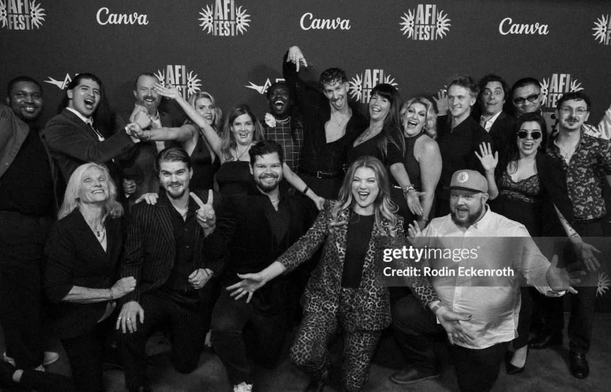 The team of 'Junkie' smiling and posing together at an event with 'AFI Fest' and 'Canva' logos in the background.