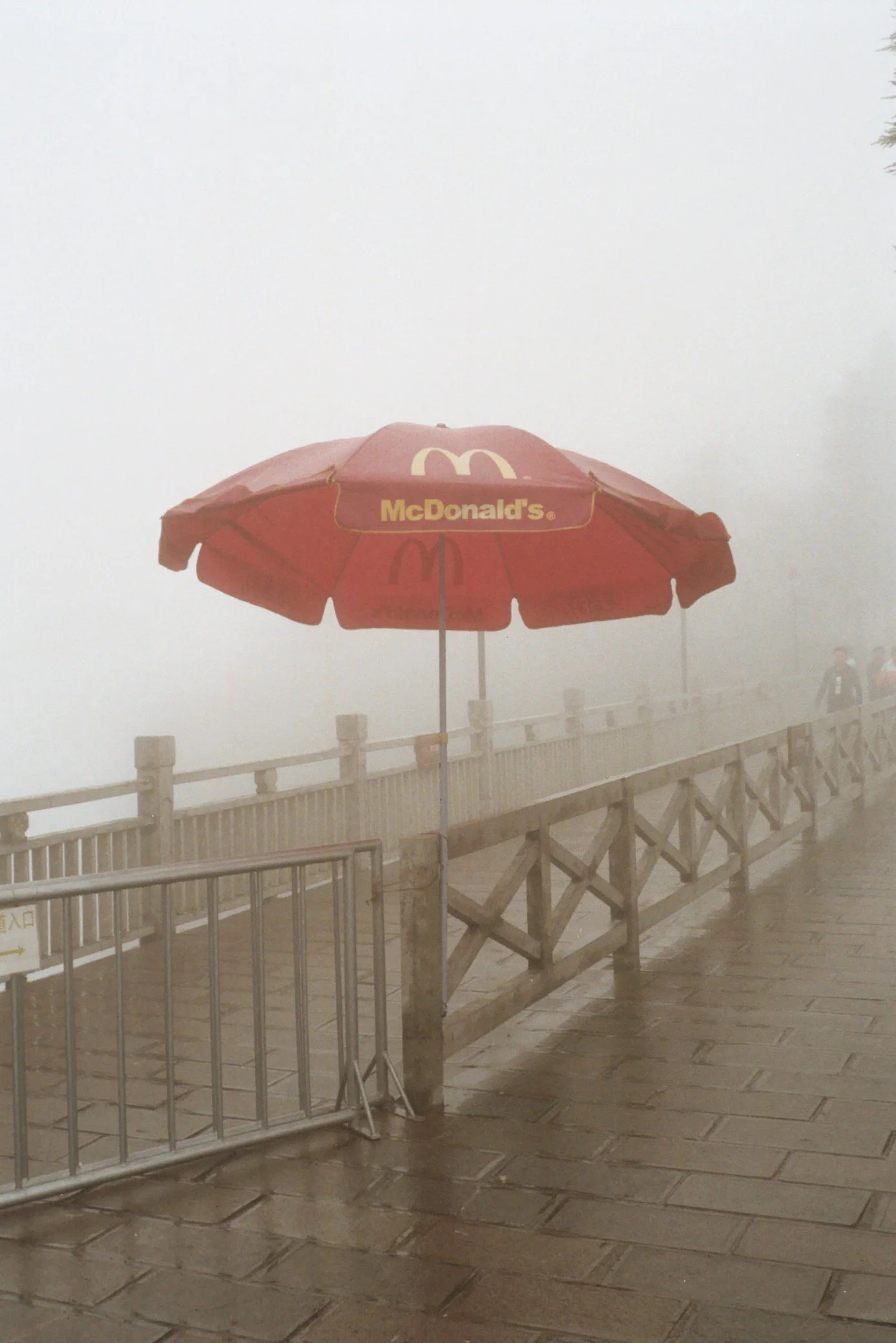 Red McDonald's umbrella on a foggy, rainy day outside.