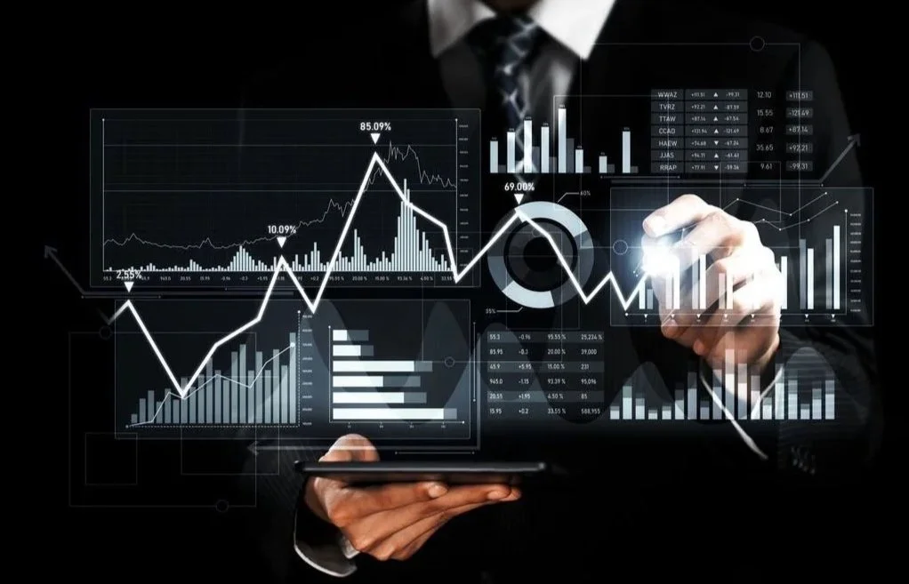 Businessman analyzing financial graphs and charts on a digital interface.