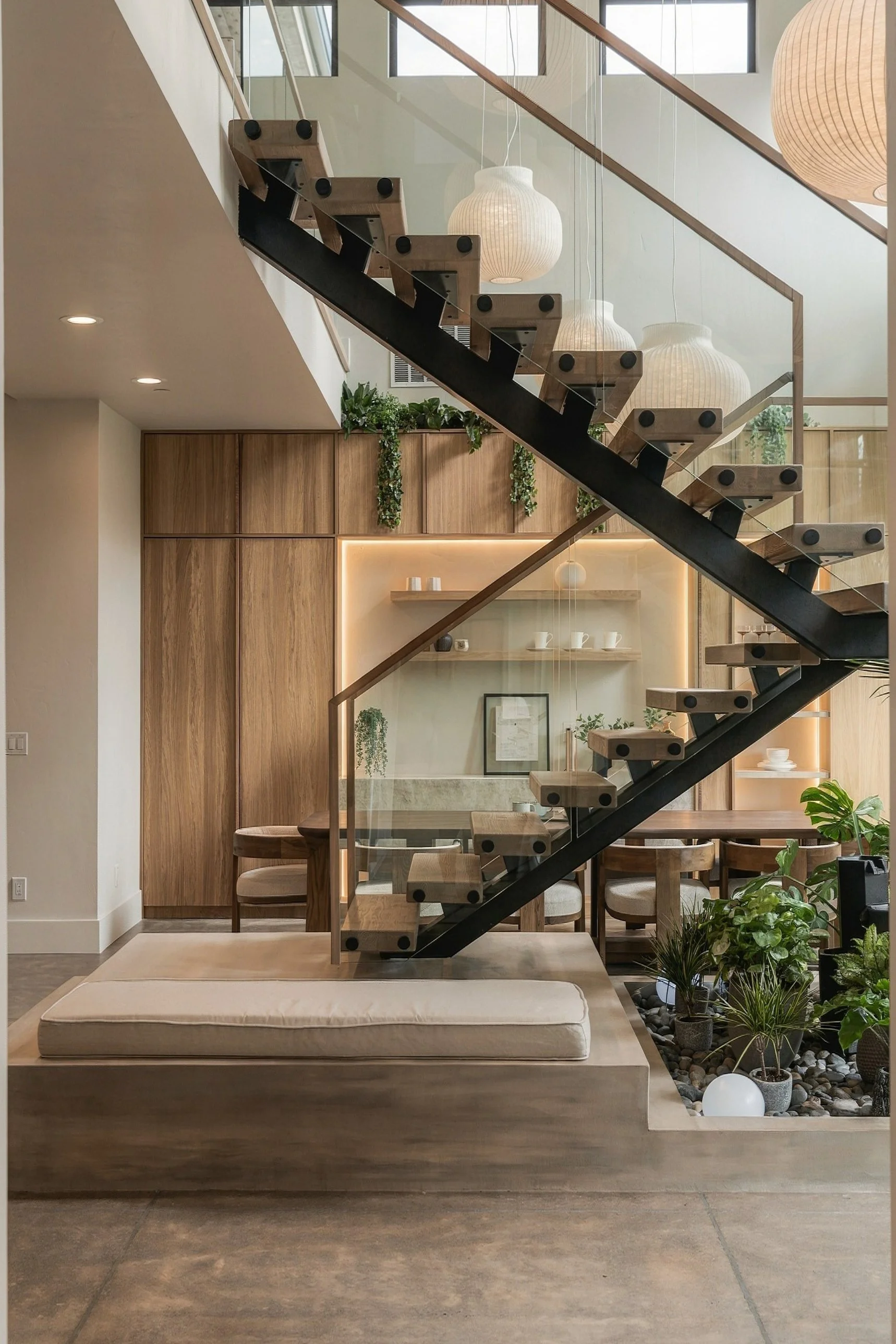 Floating timber stair with a glass rail and paper lantern pendants