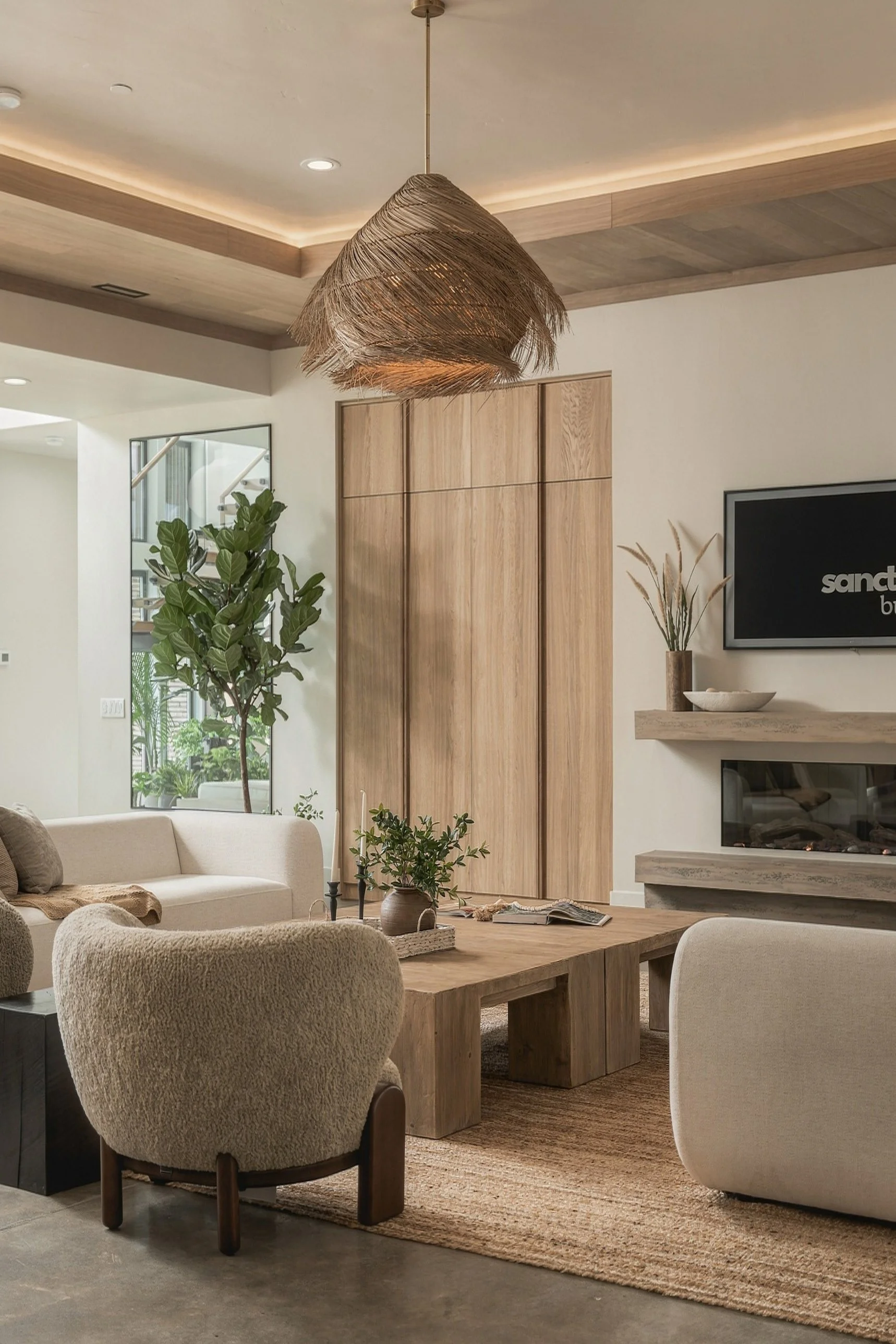 Living room with a woven pendant, linear fireplace and oak cabinetry