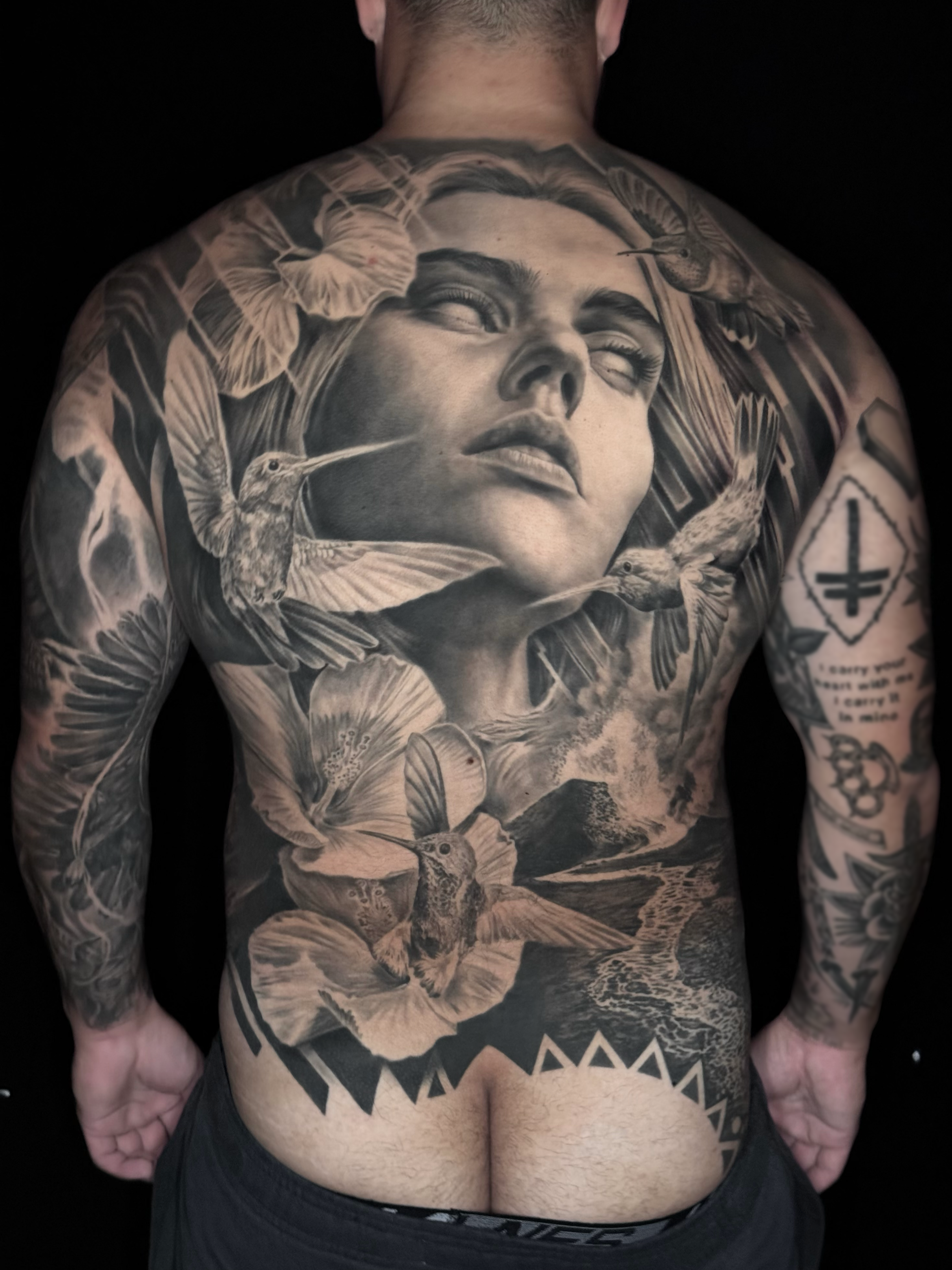 Innovative realistic black and grey tattoo Hawaii inspired girl with flowers , hummingbirds graphic design integration In Los Angeles Area, at Outer Limits tattoo shop. by Jhon Gutti