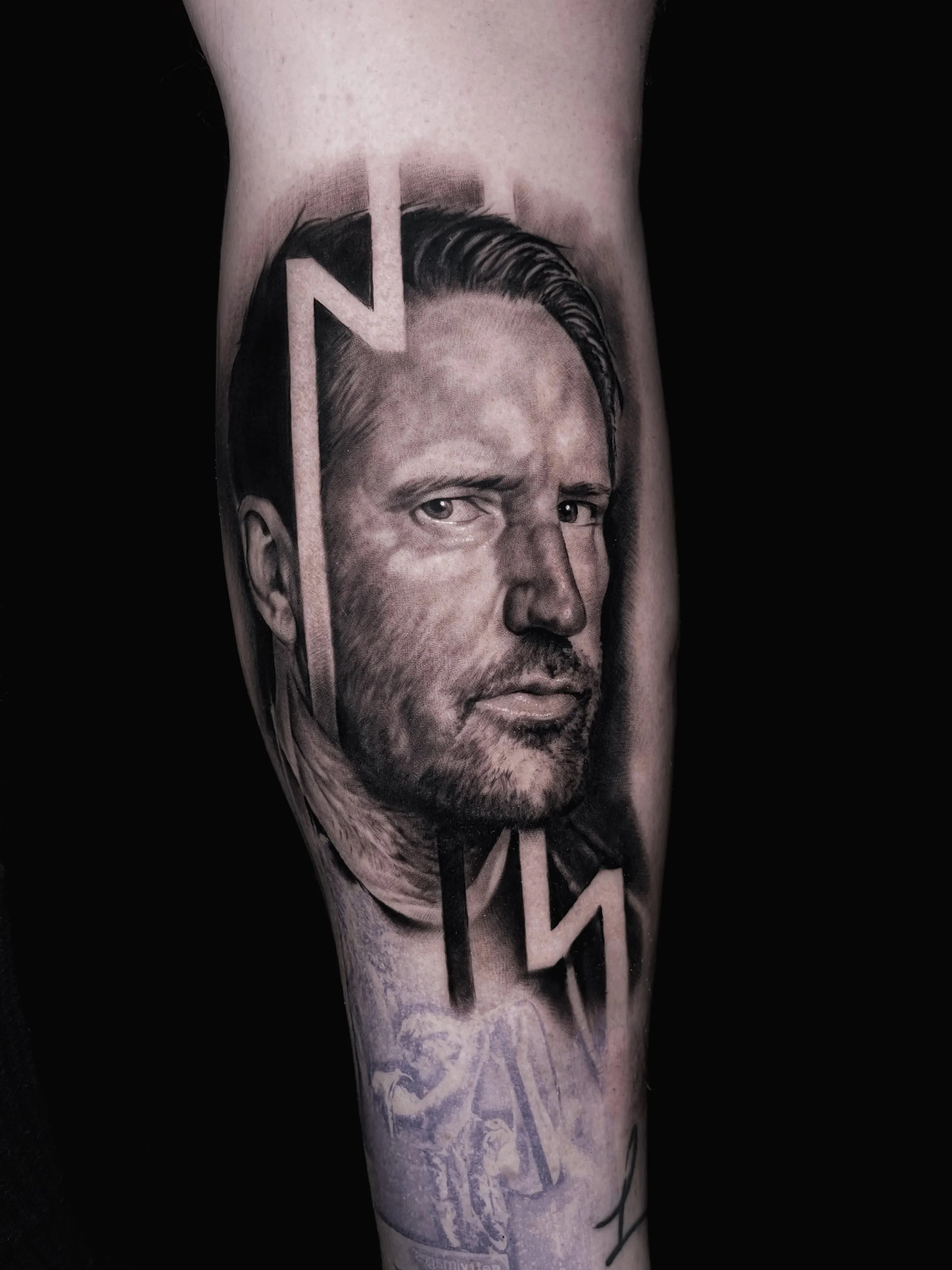 Innovative realistic black and grey tattoo portrait of Trent Reznor with graphic design integration nine Inch Nails logo In Los Angeles Area, at Outer Limits tattoo shop. by Jhon Gutti