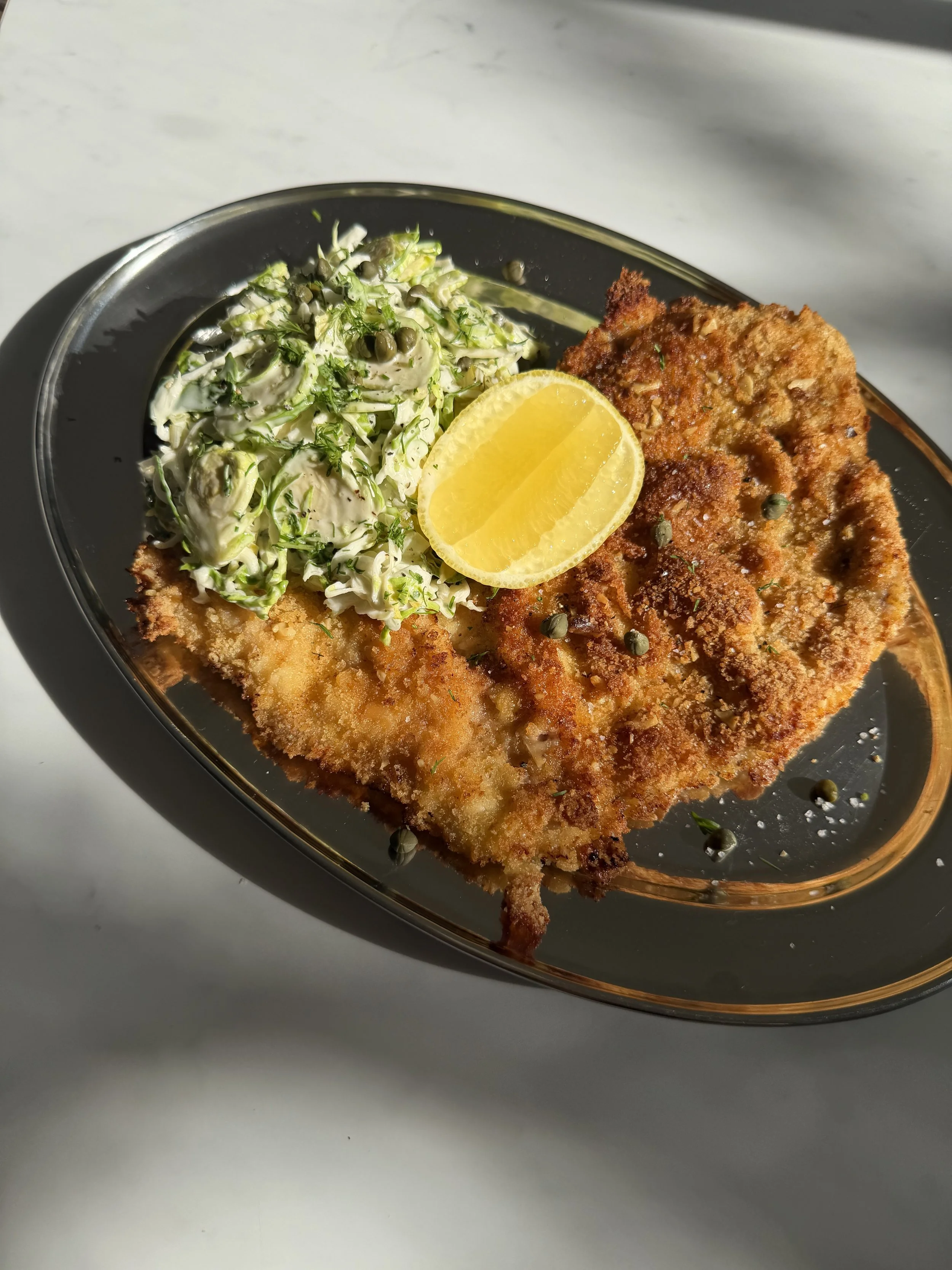 walnut crusted chicken schnitzel with brussels sprout and pickle slaw