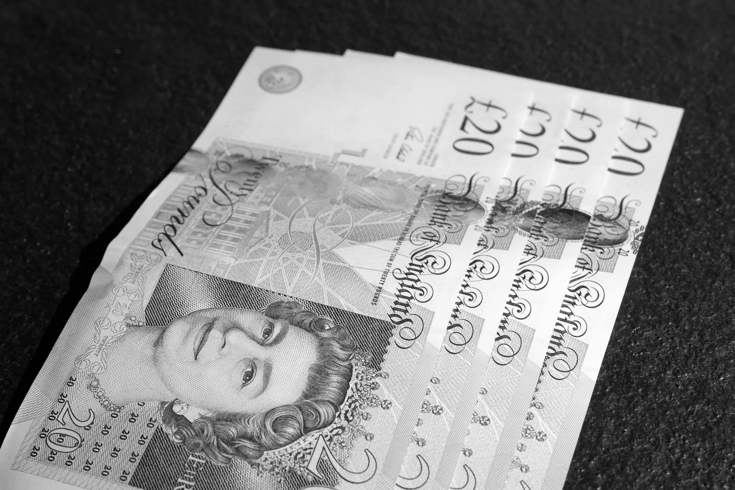 Open notebook with blank lined pages, silver pen resting on pages, background is white.