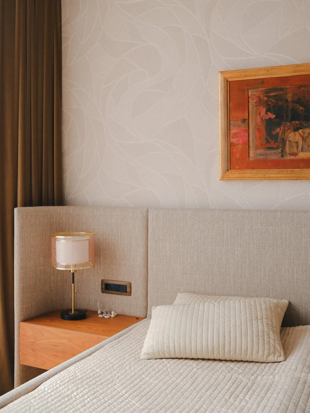 Spalnica nadaljuje občutek elegance in topline, ki se prepleta skozi celotno stanovanje - z nežnimi toni in subtilnimi zlatimi poudarki. Prostor je zasnovan umirjeno, brez odvečnih elementov, da ohranja občutek zračnosti in ravnovesja. Tehnične re&sc