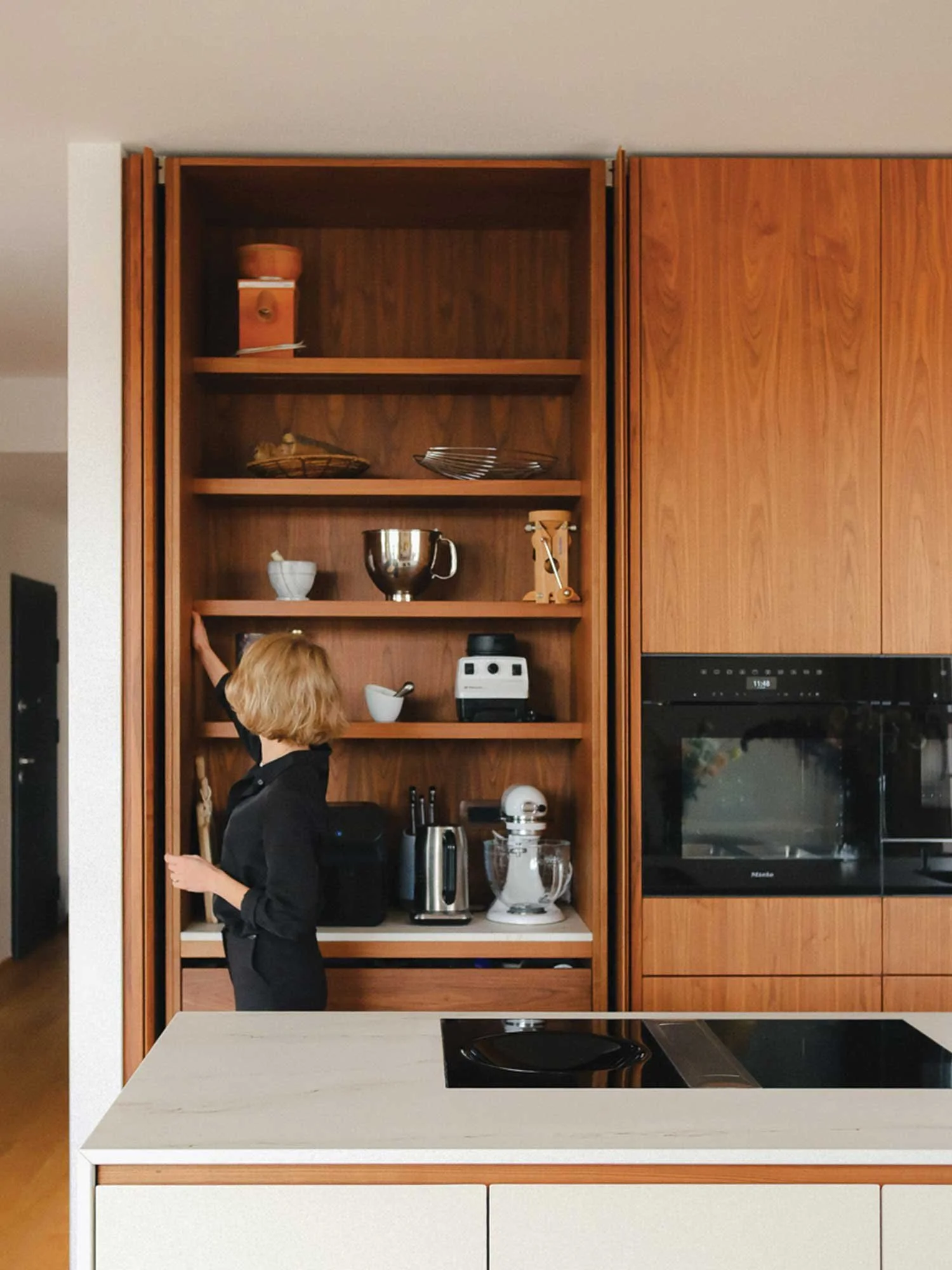 Odprta kuhinja v kuhinji s policami za skodelice in kuhinjske pripomočke.