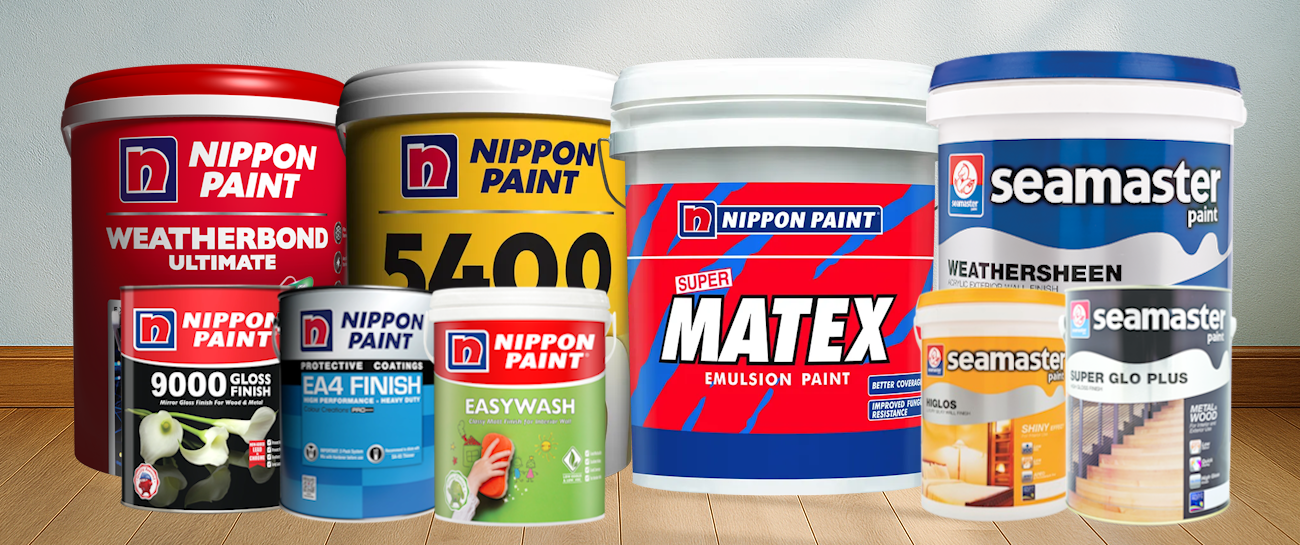 Collection of multiple paint cans and buckets on a wooden floor against gray wall, including Nippon Paint and Seamaster brands, with various labels and colors.