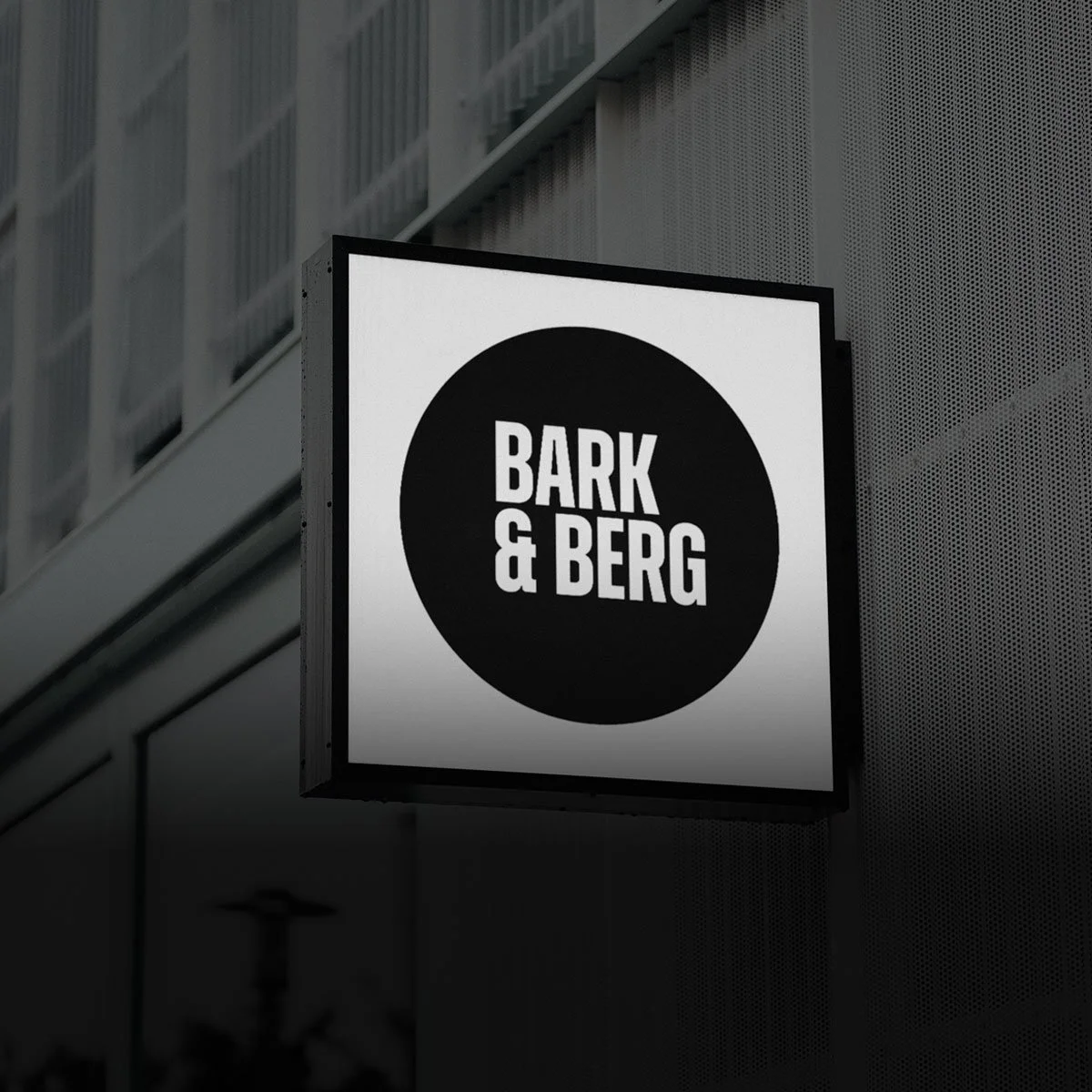 Signboard for Bark & Berg cafe or business with black text on a white background and a black circle background.