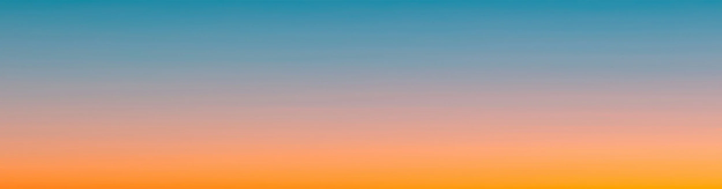 A colorful gradient sky at sunset or sunrise with shades of orange, pink, purple, and blue.