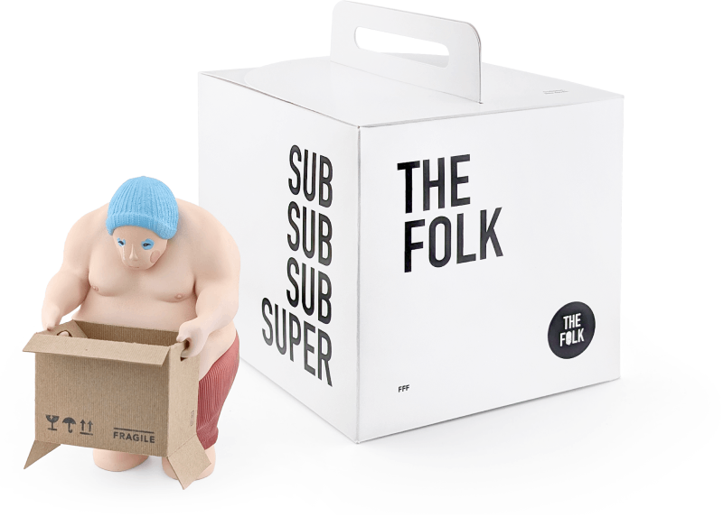 A toy figure of a person with a muscular build, wearing a blue beanie and red shorts, holding a small cardboard box labeled 'FRAGILE,' next to a white box with black text that reads 'SUB SUB SUB SUPER' and 'THE FOLK.'